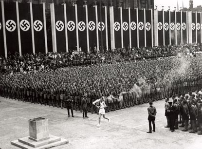 The Olympic torch arrives at the start of the summer Olympics in Berlin, 1936.