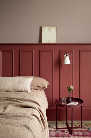 two tones of pink painted bedroom with linen bedding and wooden paneling