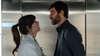 Jesica and Lluis look into each other's eyes in a lift