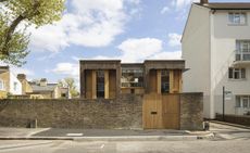 Southwark brick house by Satish Jassal as it sits behind a brick wall on a sleepy residential street in South London