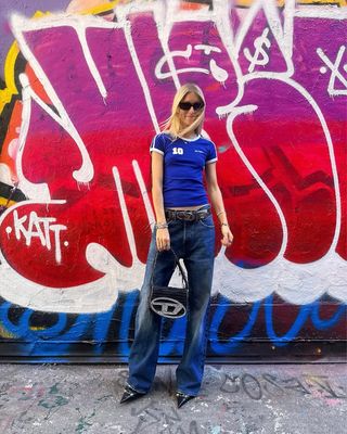 woman wearing fitted t-shirt and baggy jeans with stiletto heels