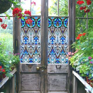 blue stained glass style window film on doors of greenhouse