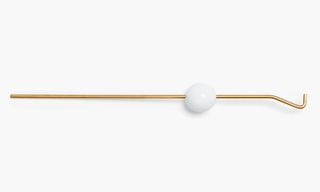 Gold candle-snuffing tool with white ball on