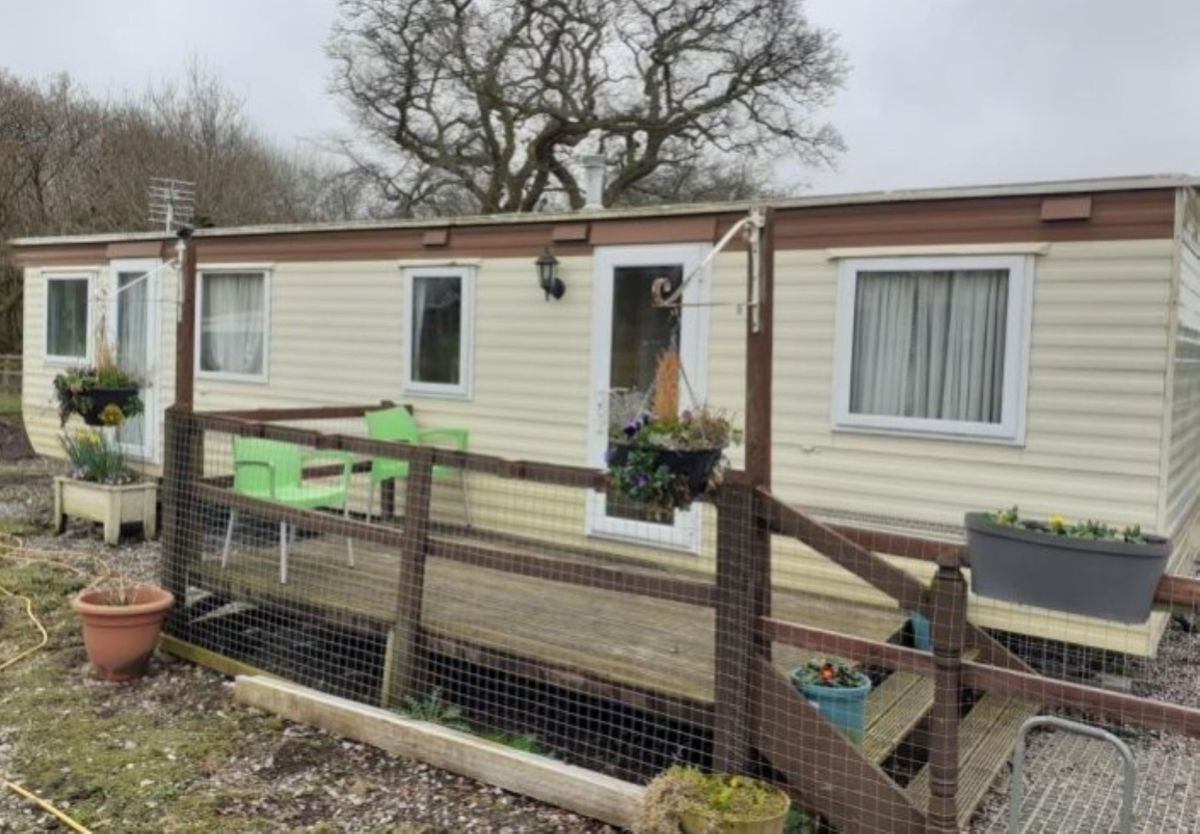 A static caravan with small porch and white aluminium walls