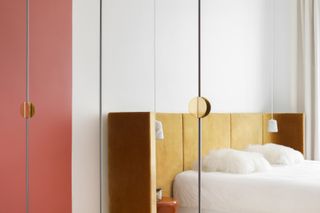 A bedroom with a mirrored door wardrobe