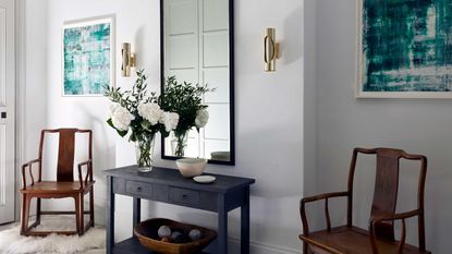 entryway with mirror, console table and wooden chairs