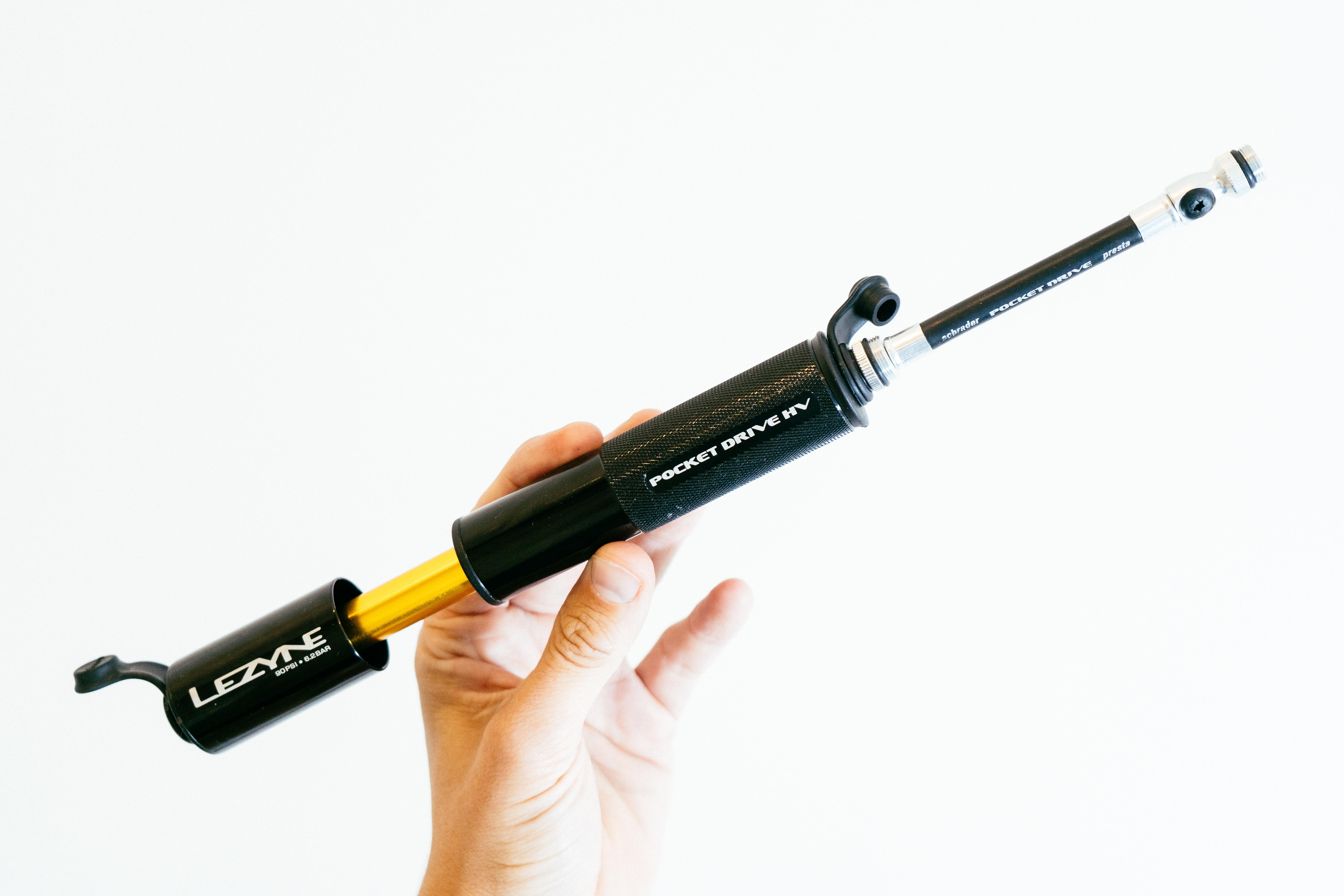 a close up of a black bike pump extended with a gold shaft