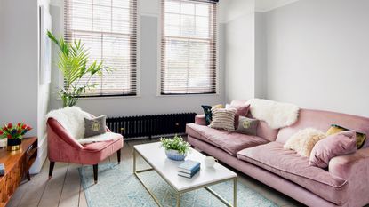 Light grey living room with pink velvet sofa and gold coffee table