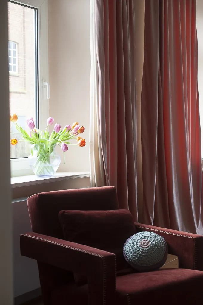 An armchair with a small embroiderd pillow