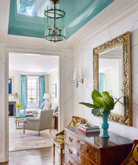 a foyer with white walls and a blue, high gloss painted ceiling