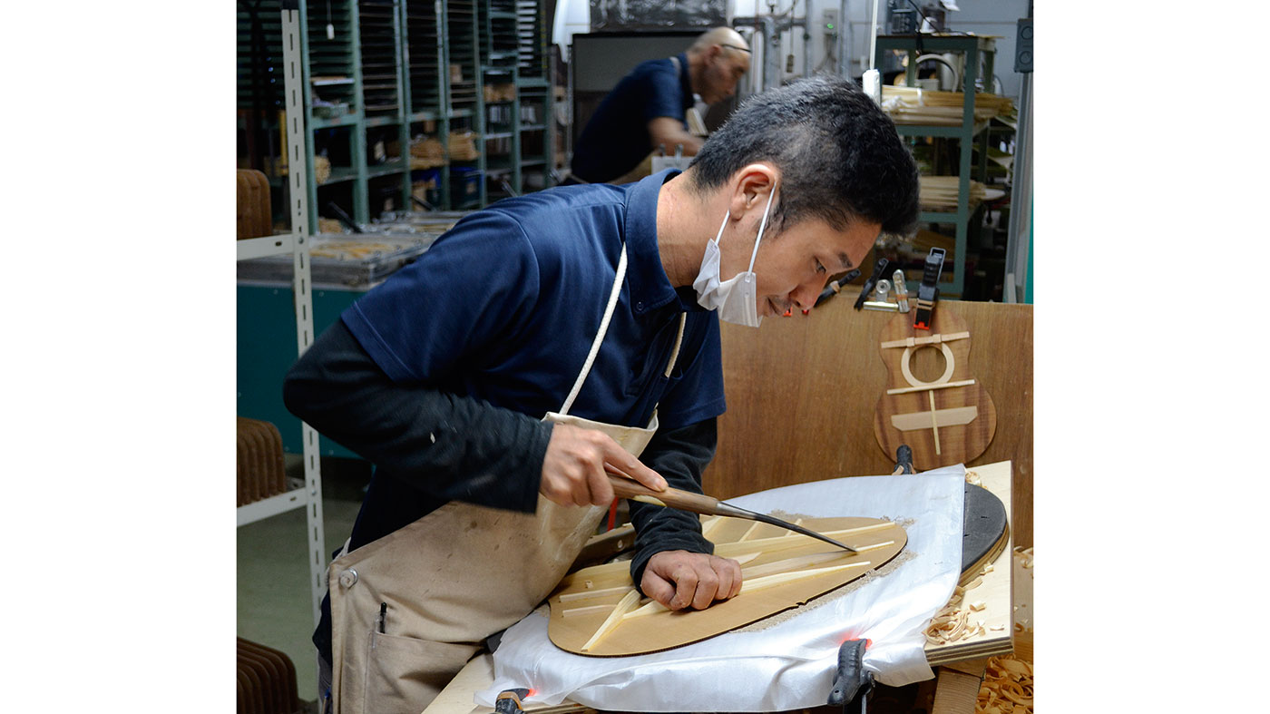 With rapid strokes, a craftsman shapes braces for optimum strength and sonority
