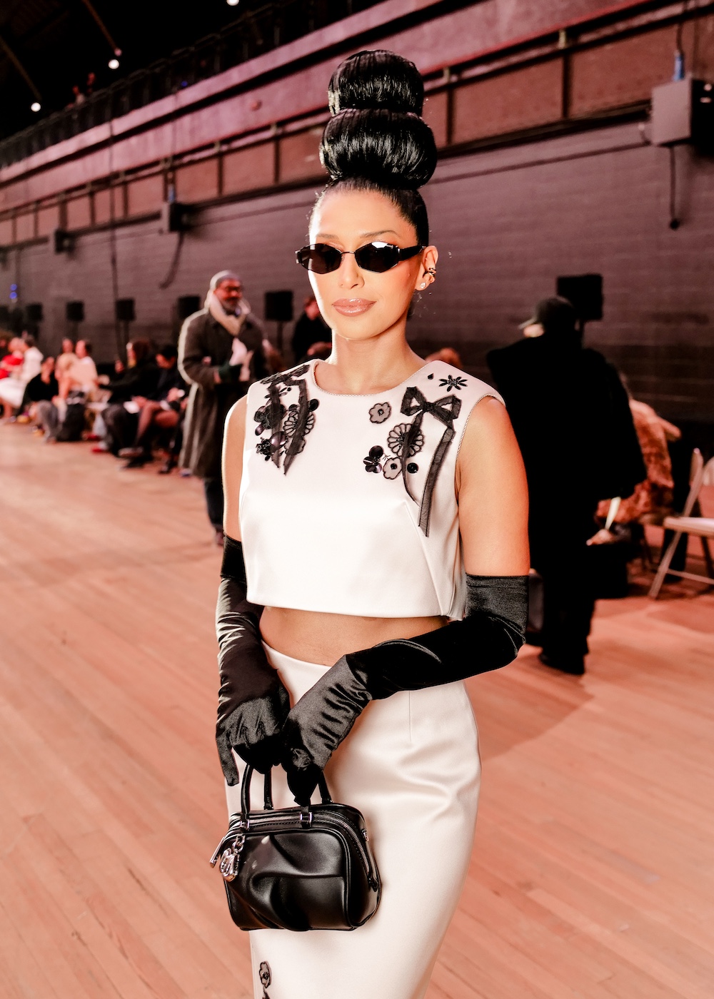 Priya Shukla poses in a black and white floral applique matching top and skirt set at the Marc Jacobs spring 2026 fashion show during NYFW.