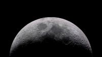 A crescent Moon with its cratered surface lit against a black sky.