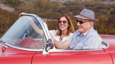 Couple in classic red convertible car