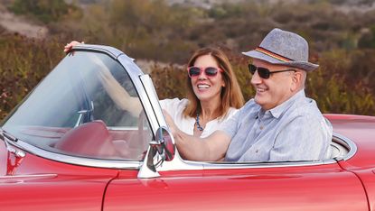 Couple in classic red convertible car