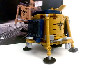 a model of a gold and blue lunar lander made out of toy building blocks