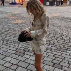 Influencer @lucywilliams02 wears a floral minidress with sculptural wedge thong heels.
