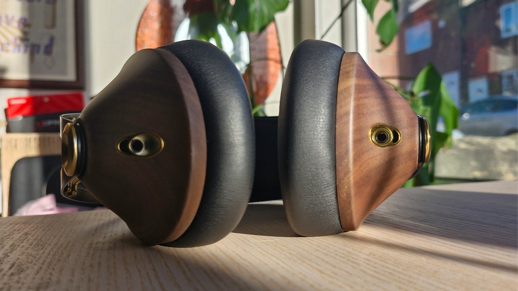 Close up of the cable inputs of the Meze Audio 99 Classics 2nd, on a wooden table