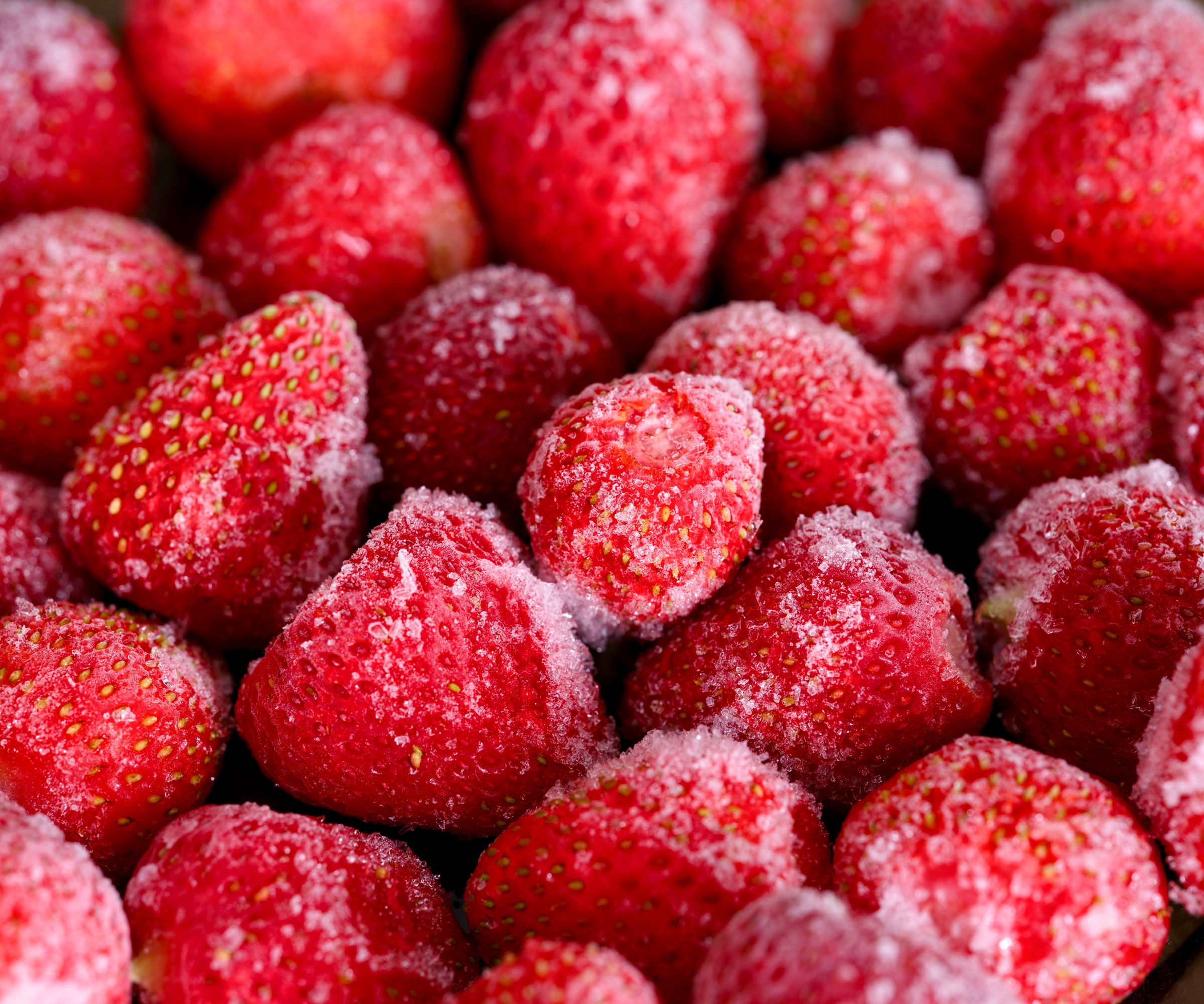 frozen strawberry fruits with ice dust