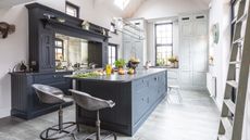 Deep blue Shaker-style kitchen with silver barstools
