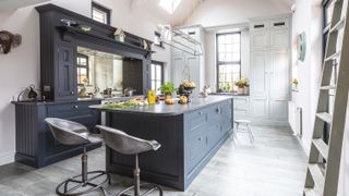Deep blue Shaker-style kitchen with silver barstools