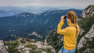 Woman overlooking a valley using binoculars
