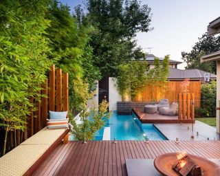 A pool deck area in warm wood with additional seating area
