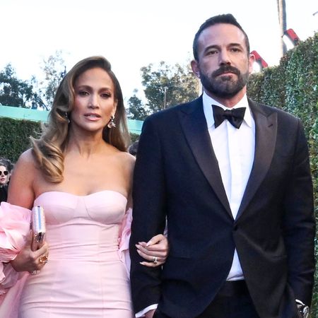 Jennifer Lopez wears a light pink strapless gown and Ben Affleck wears a tuxedo at the Golden Globes 2024