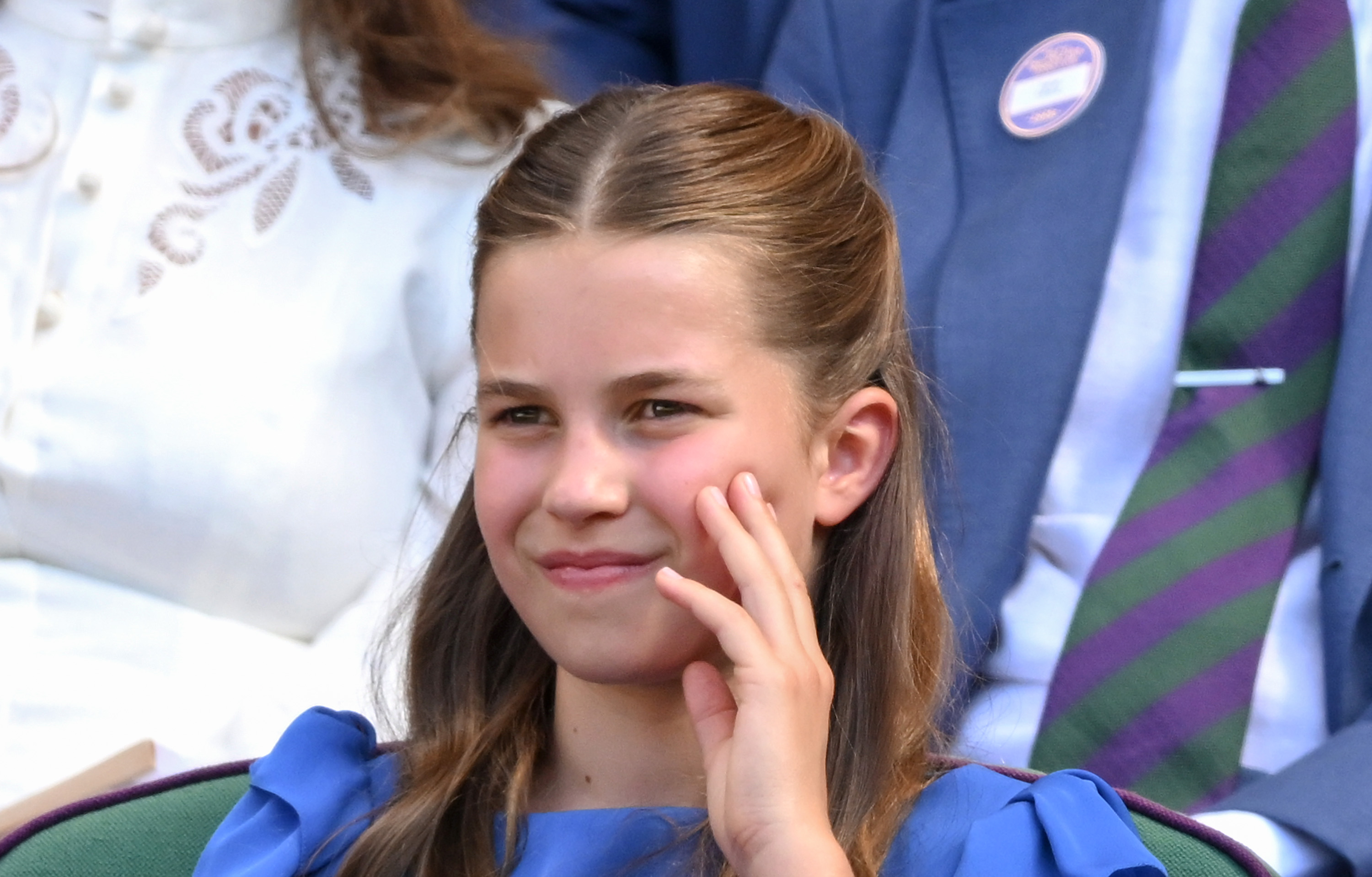 Princess Charlotte sitting with her hand touching her cheek at Wimbledon