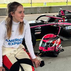 Nicole Havrda in her American Express F1 Academy racing suit sitting trackside by her car.