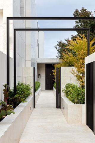 Pathway to the garden with sculptural features at Armadale Residence in Australia