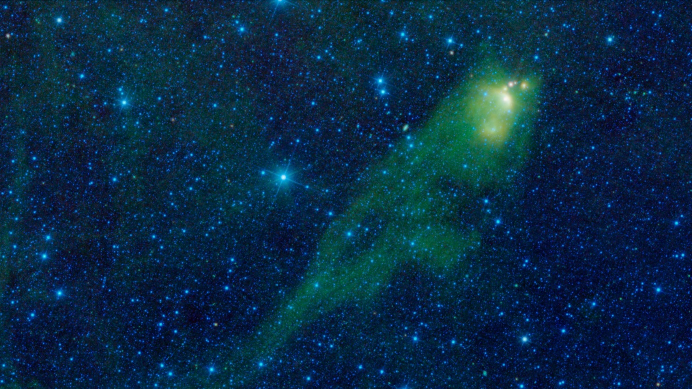 spacecraft photo of a large, green tadpole-shaped nebula in deep space, with lots of bright stars in the background