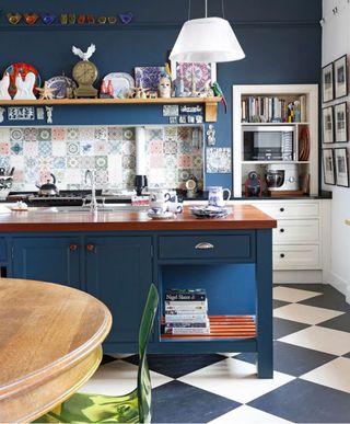 Blue and white checkerboard kitchen flooring in a dark blue scheme with Morrocan-tiled backsplash.