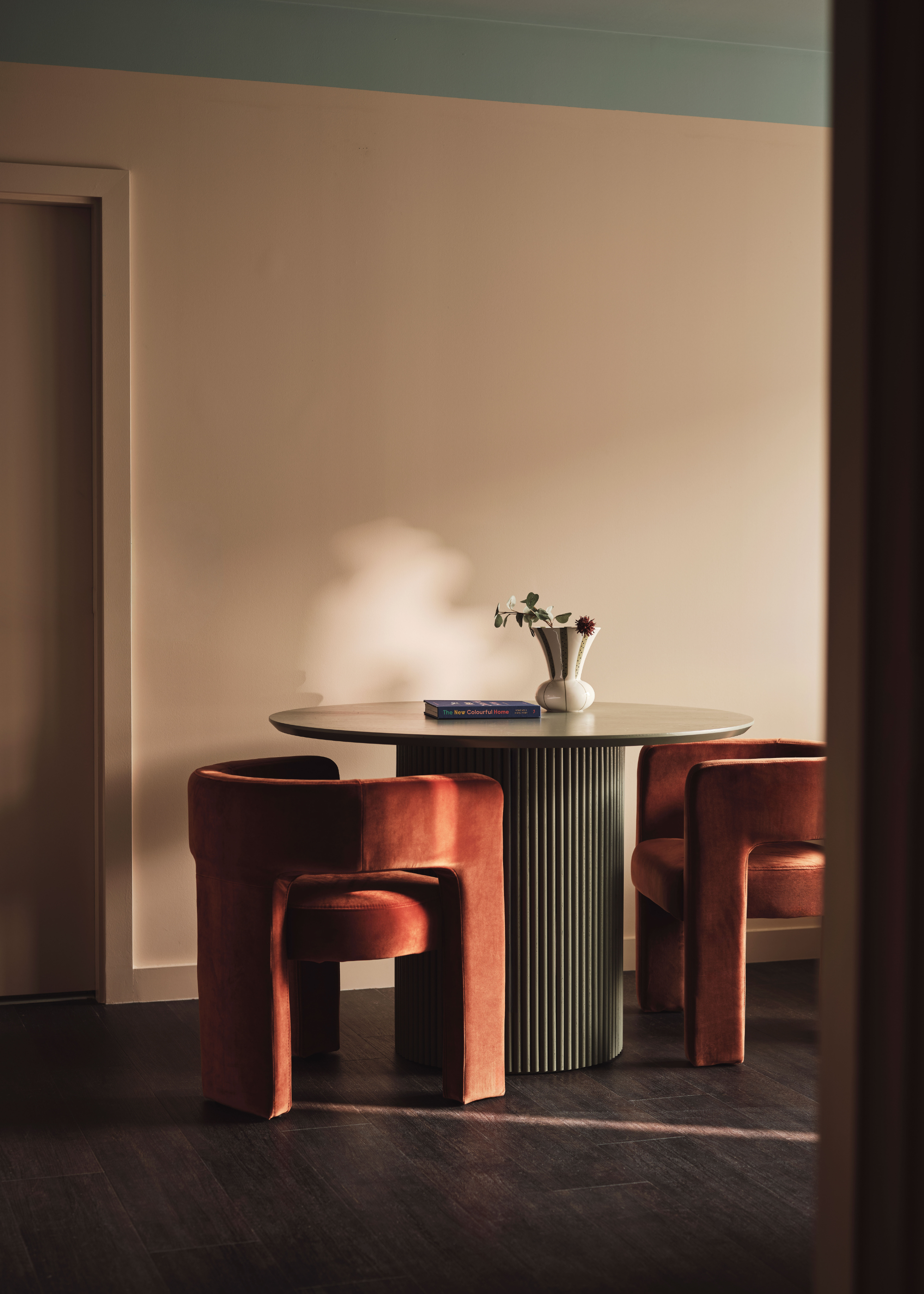 Two burnt orange chairs around a circular table