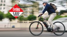 a professional businessman commutes to work on his electric battery powered ebike wearing casual business clothing and a helmet and backpack along a bike lane through the car traffic filled streets of San Diego, California, USA