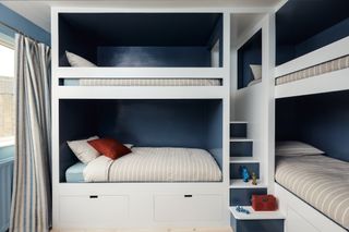 teen boys bedroom with multiple bunks, blue interior, stripe bedding, blue stripe drapes