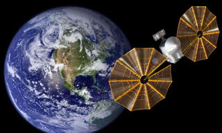 An illustration shows the LUCY spacecraft as it heads back to Earth for a gravity assist in late 2024