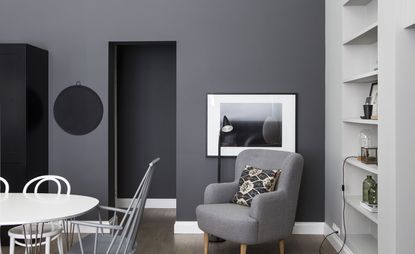 Seating area in guest hotel bedroom with grey walls and white/grey interior 
