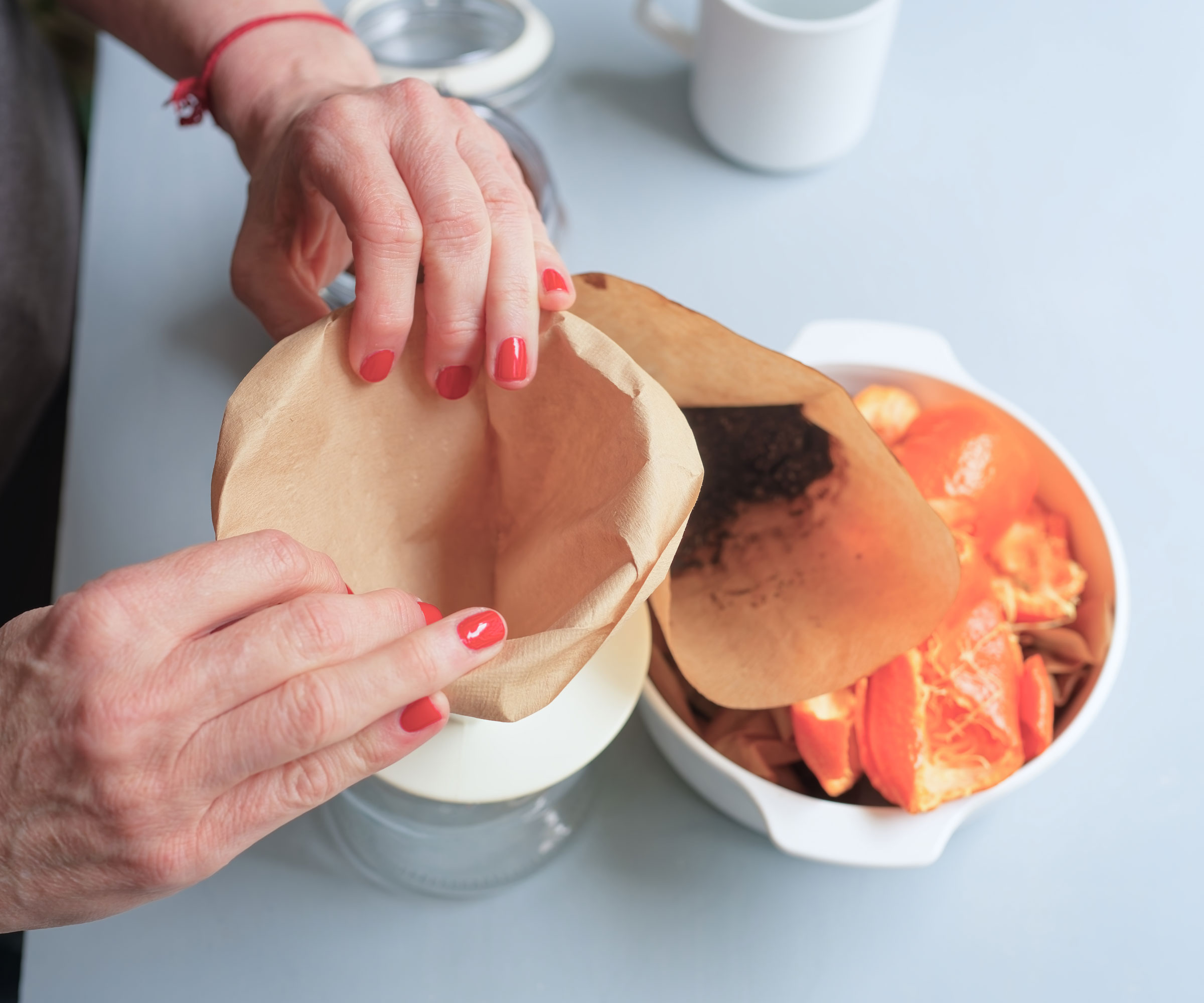 hands preparing coffee filter in cone near fruit