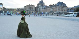 Woman dressed as Marie Antoinette in a French town square.