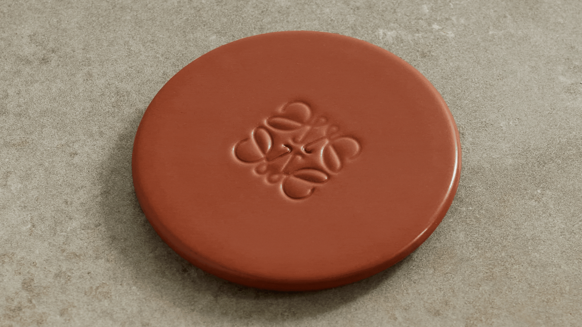 A green candle with a tan Loewe candle lid in a GIF