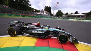 Lewis Hamilton&#039;s black Mercedes F1 car rounds a bend at Spa at the Belgian Grand Prix.