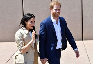 Britain's Prince Harry and his wife Meghan walk outside the Sydneys iconic Opera House on October 16, 2018