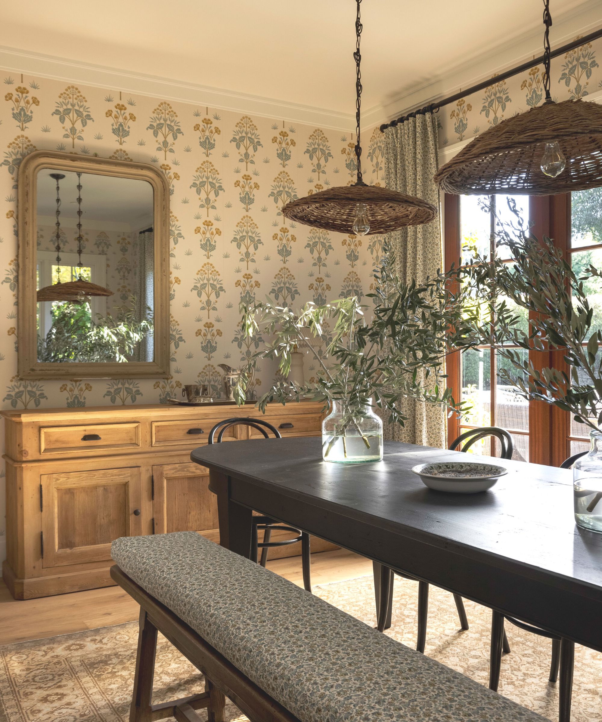 dining room with bench and wallpaper soft colors and wooden floors with glass doors to garden
