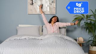 A Tom's Guide sleep product tester stretches in bed after a great night's sleep