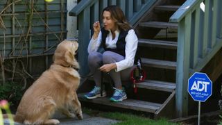 A dogwalker and a dog in front of a home protected by ADT