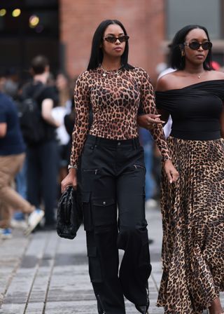 woman wearing sheer leopard print top, jeans, and black shoes