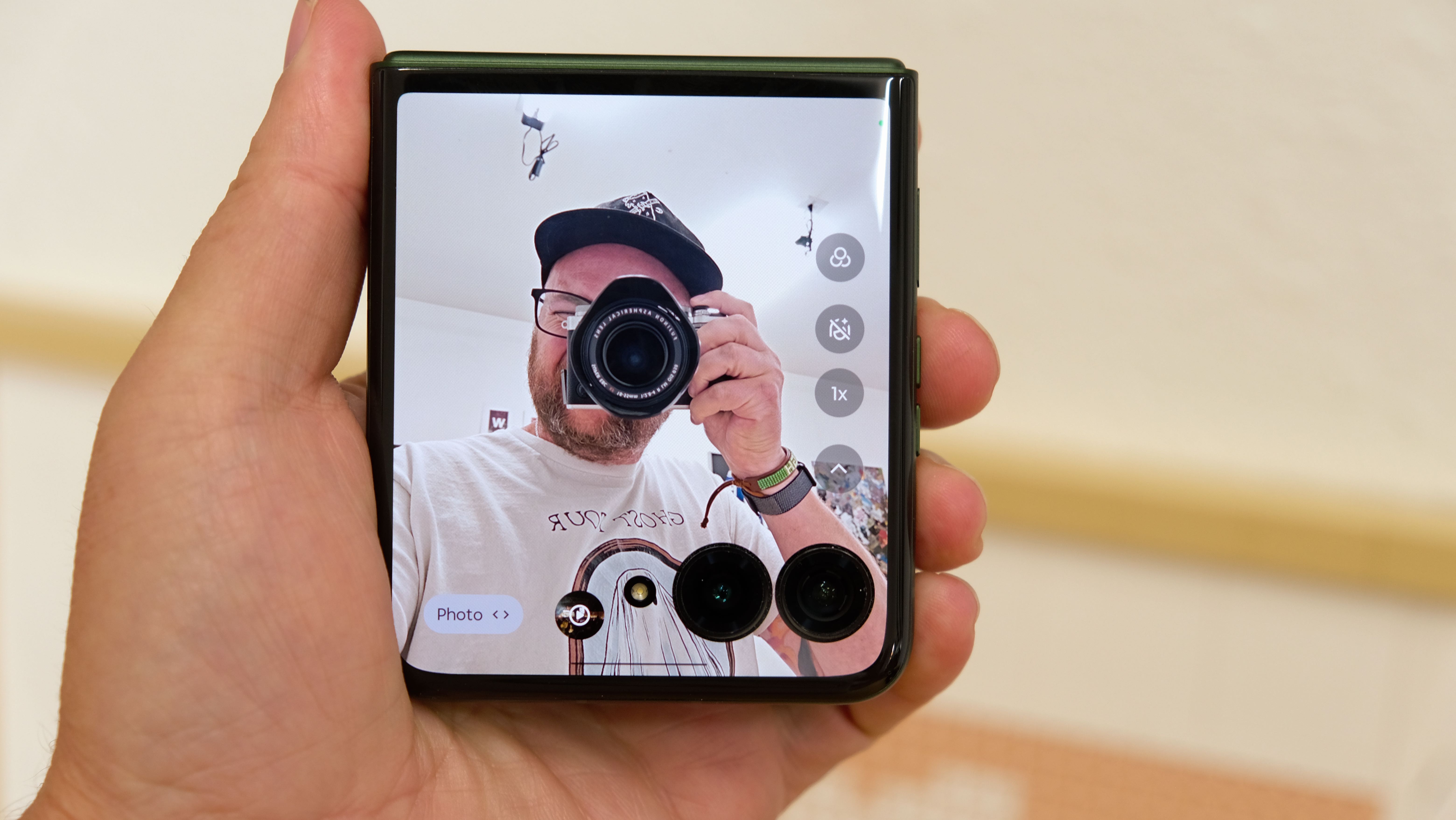 The Motorola Razr Plus 2026 in the hand and on a wooden table