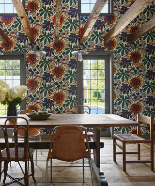 dining area with wooden table and midcentury style chairs with floral wallpaper