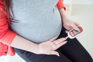 Pregnant woman checking blood sugar